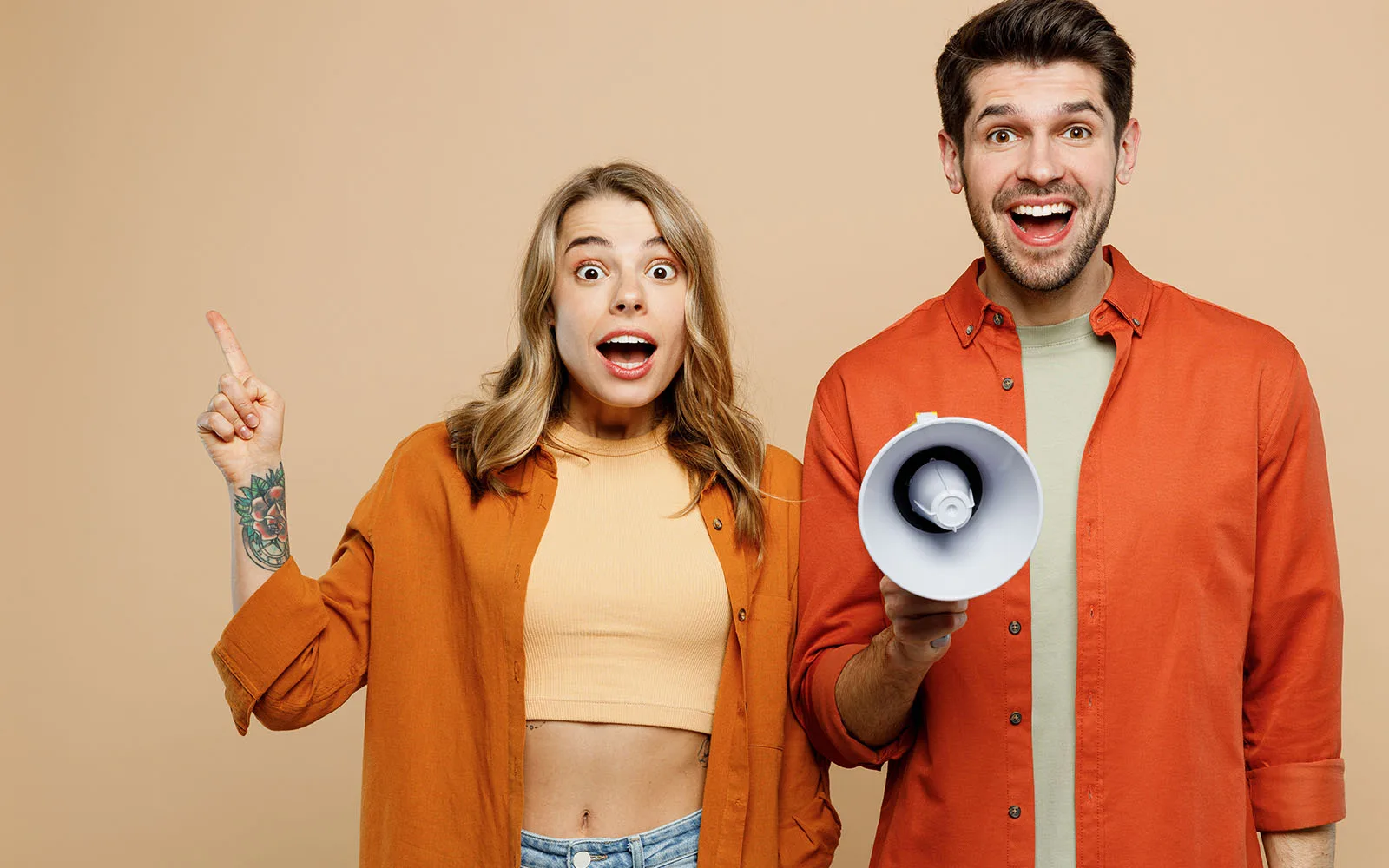 A man holding a megaphone next to a woman with her finger pointing up